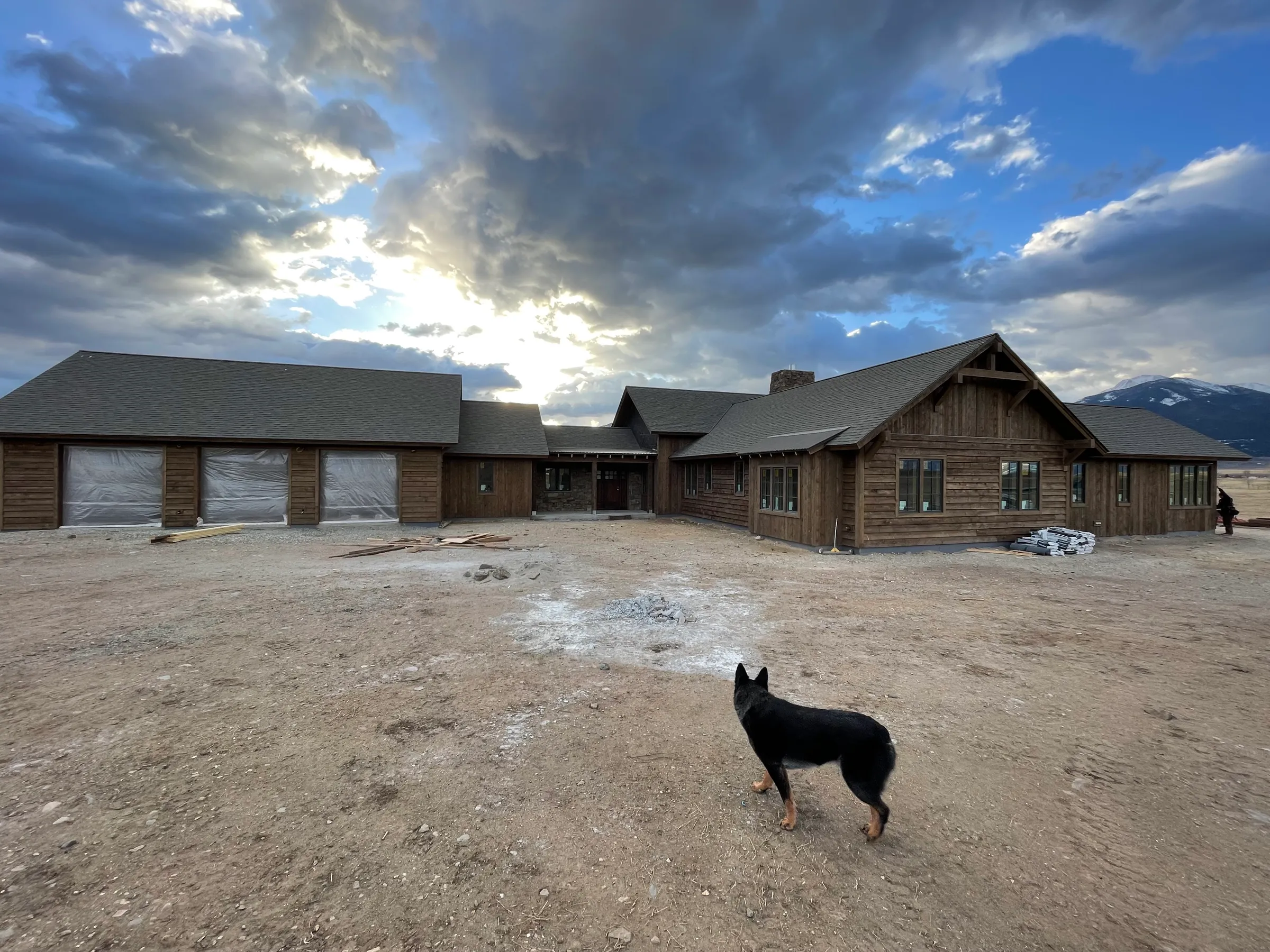 Large custom ranch home with dramatic sky