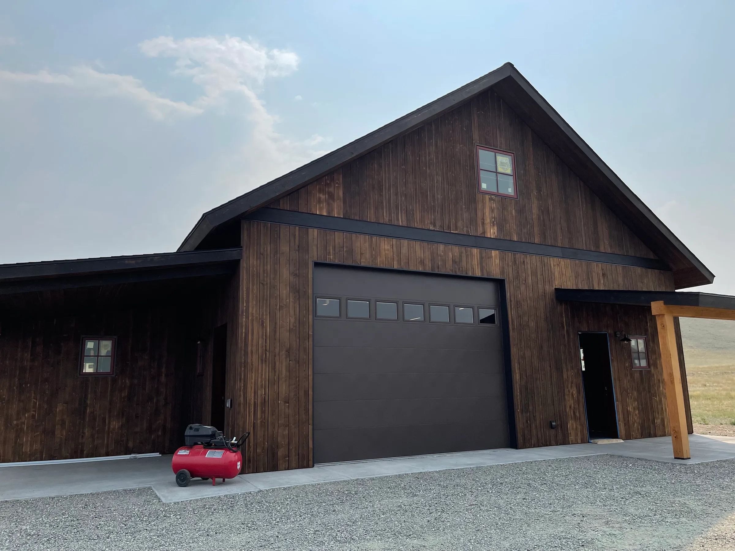 Dark wood-clad shop building with metal accents